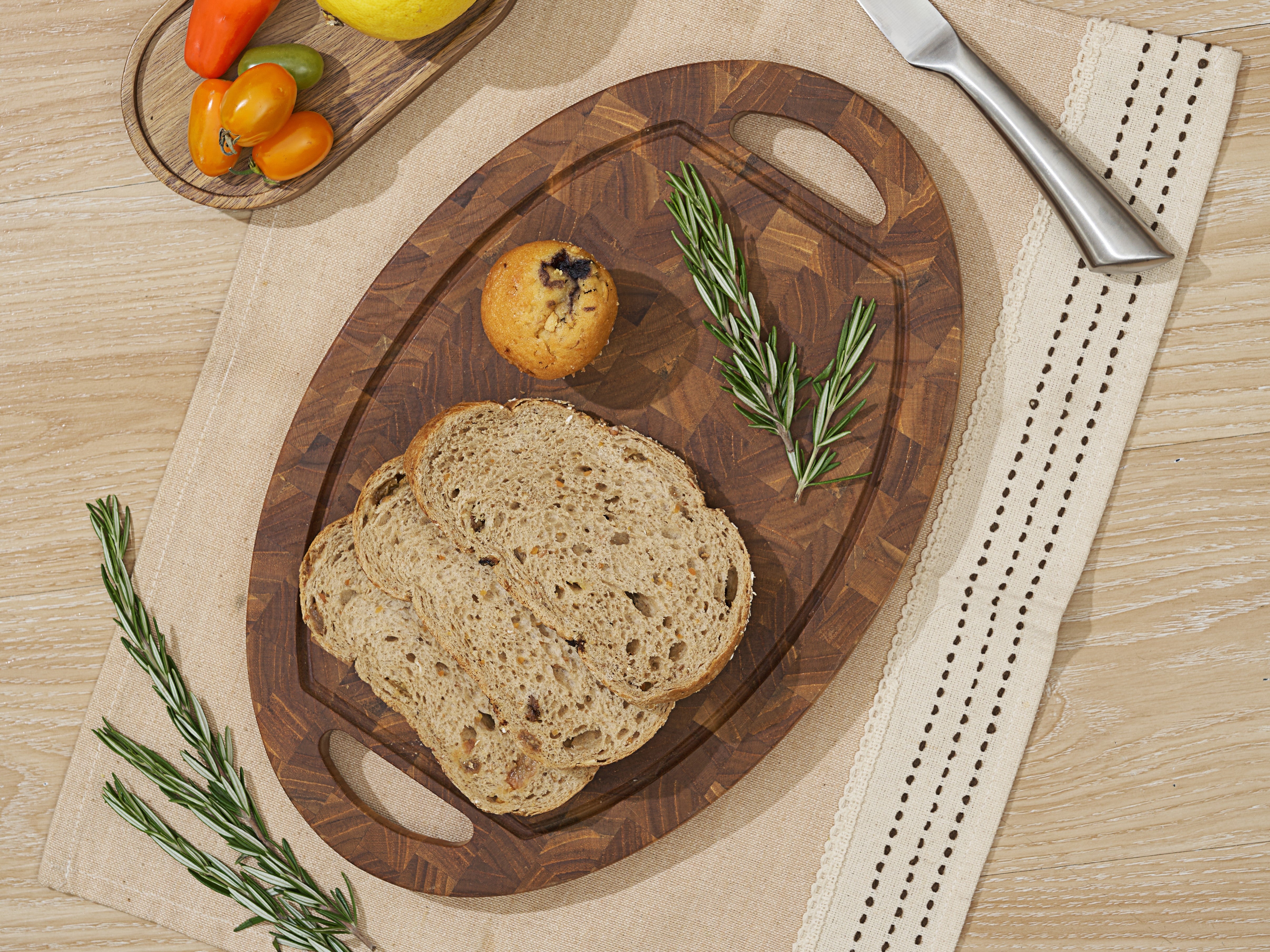 Coupe oval teak cutting board with cut-out handles