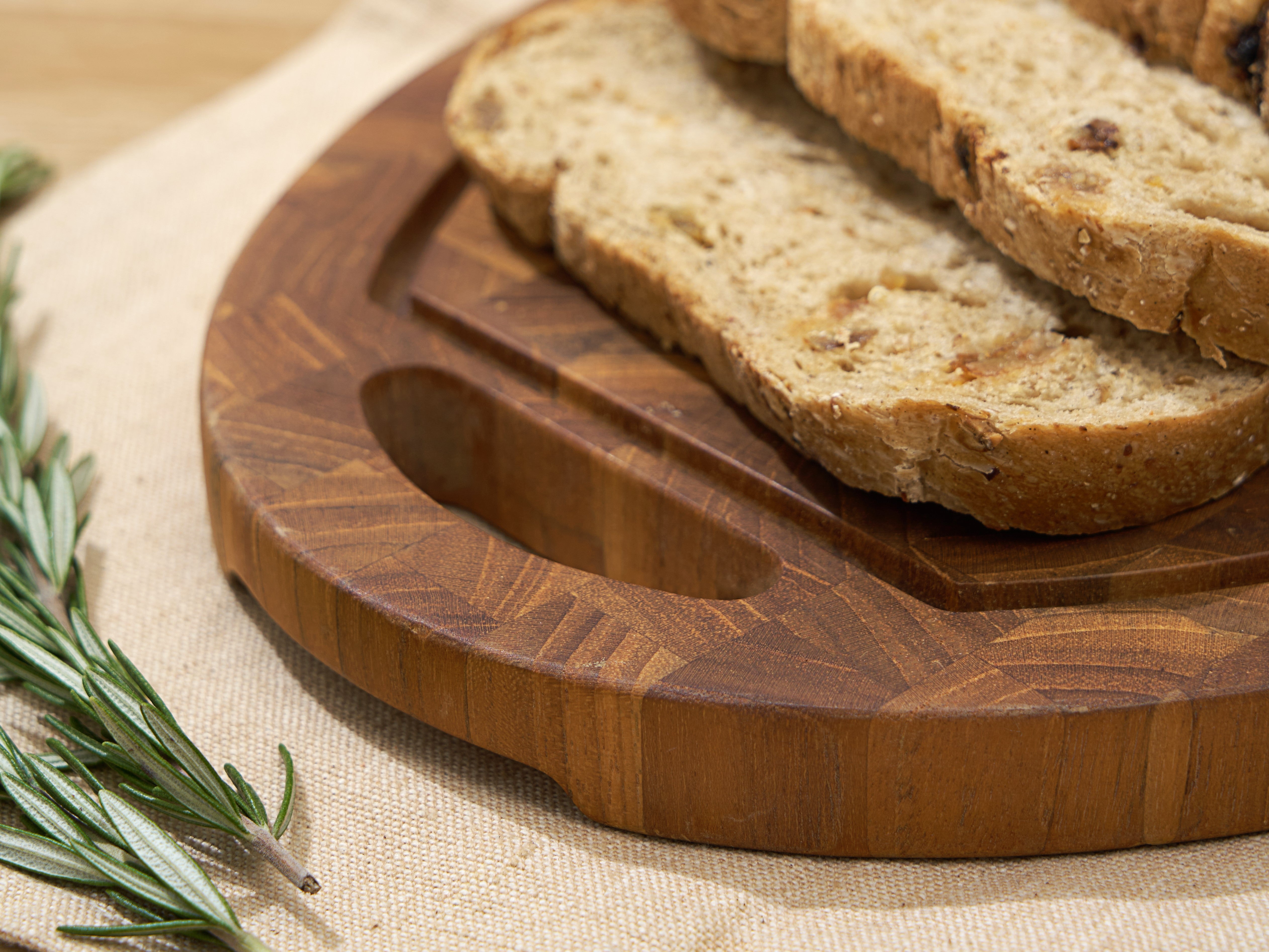 Coupe teak cutting board in kitchen setting